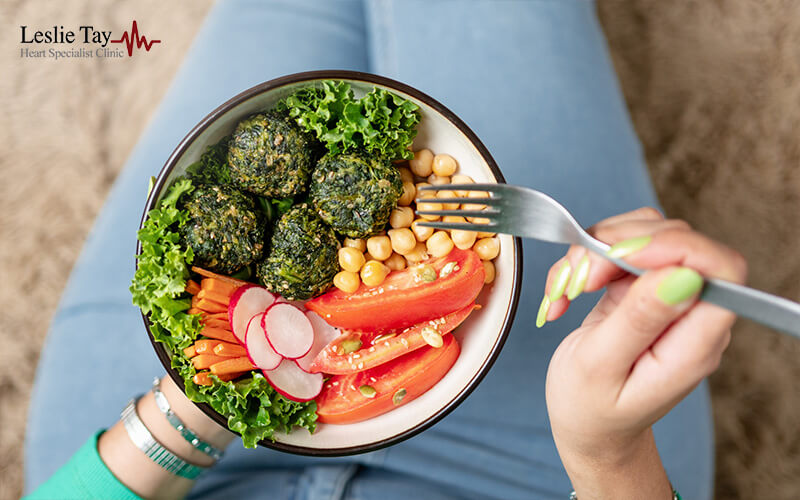 Girl Holds A Bowl With Healthy Food Sitting On The Floor
