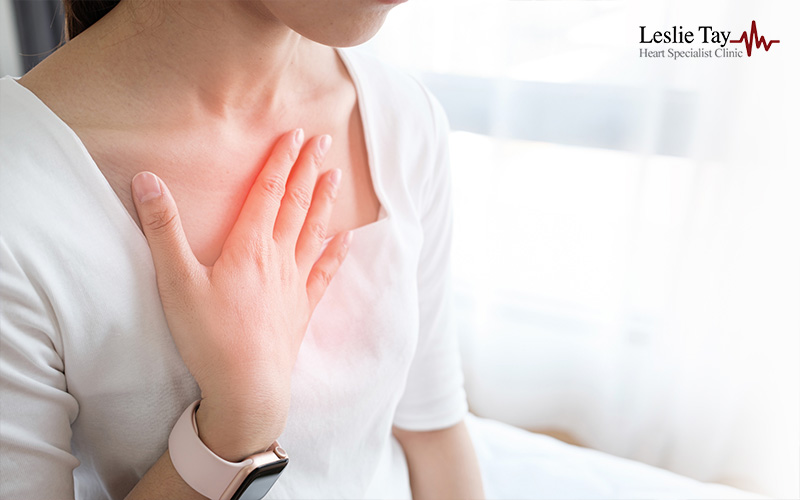 Woman touching chest area in discomfort