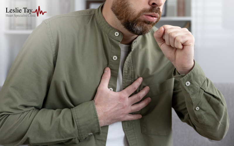 A man clutching his chest indoors.