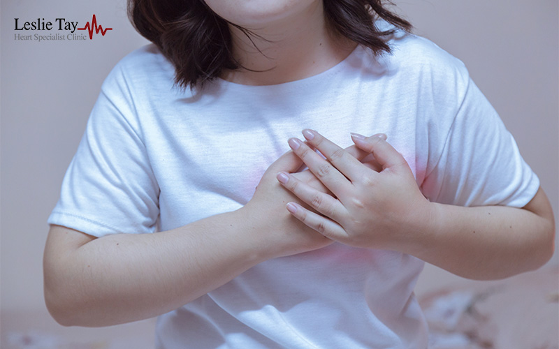 Person holding their chest, suggesting heart discomfort.