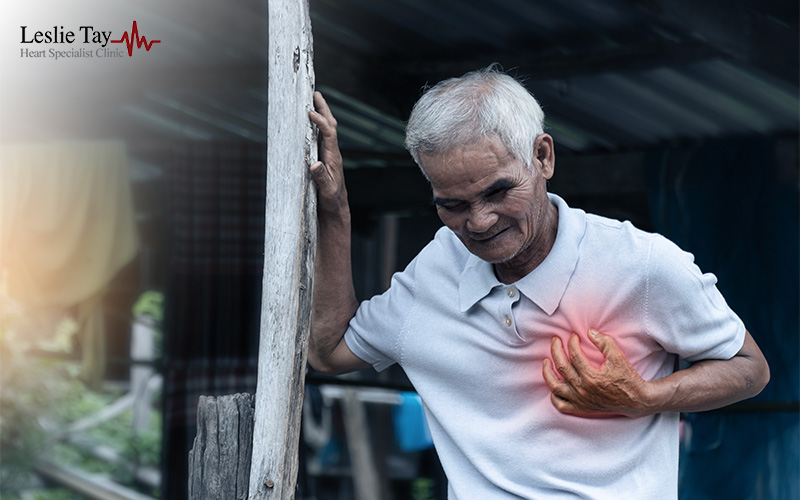 A close-up of an elderly man grimacing while clutching his chest, with a red glow over his heart area.